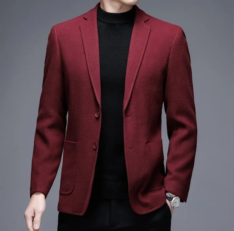 Man wearing a solid grey loose-fit woolen suit jacket with long sleeves.