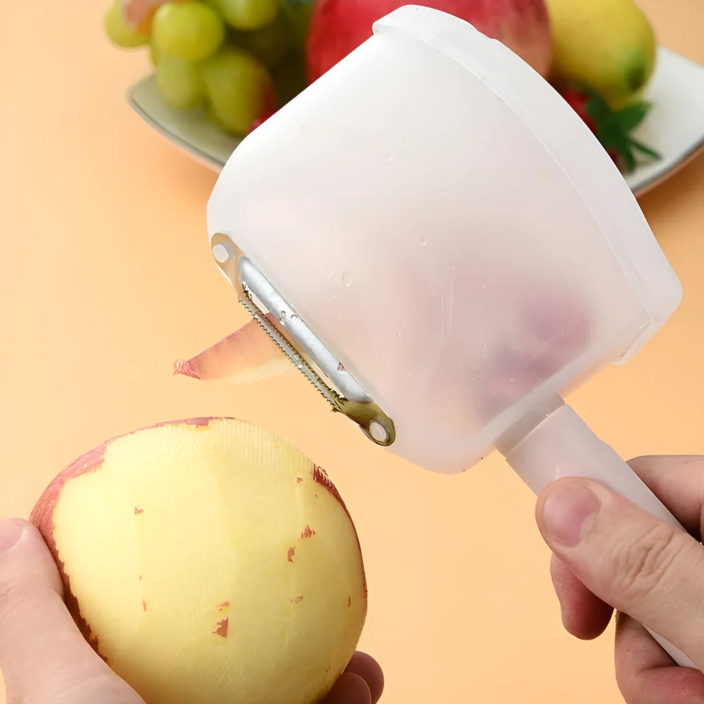 Stainless steel handle fruit peeler in pink colour with PP plastic body on a wooden surface