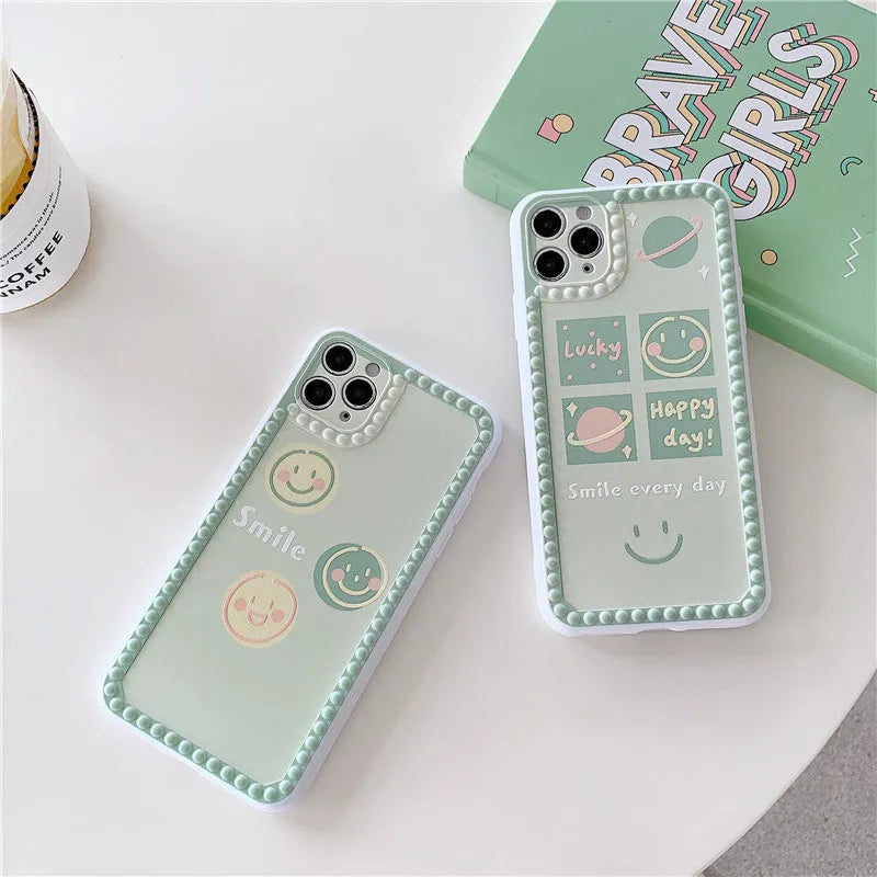 Green TPU iPhone case with a smiley face geometric pattern and polka dot frame.