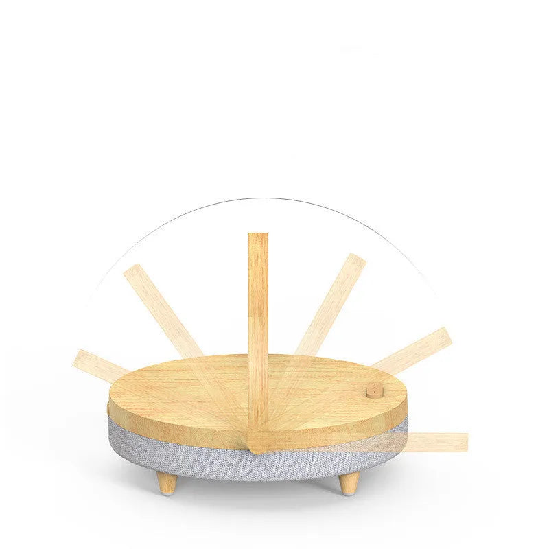 Marble pattern wireless charging LED night light with Bluetooth speaker and phone holder on a wooden nightstand.