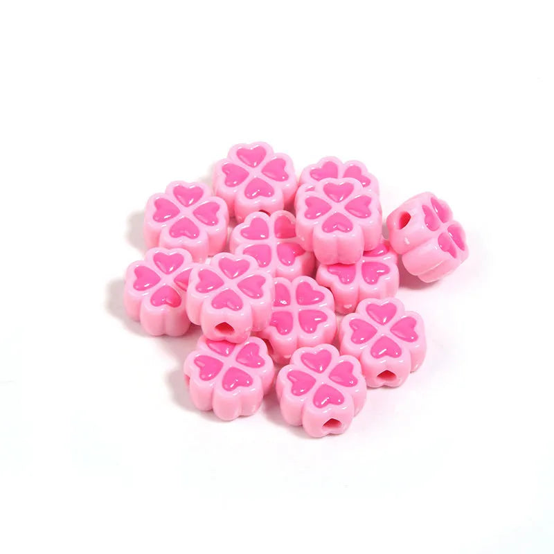 Frosted acrylic four-leaf clover shaped beads in mixed colours on white background