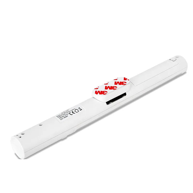 Slender white human body induction cabinet light with magnetic strip for mounting on metallic surfaces.