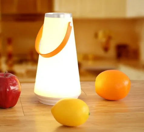 White rechargeable LED bedside night light with touch control on a wooden table.