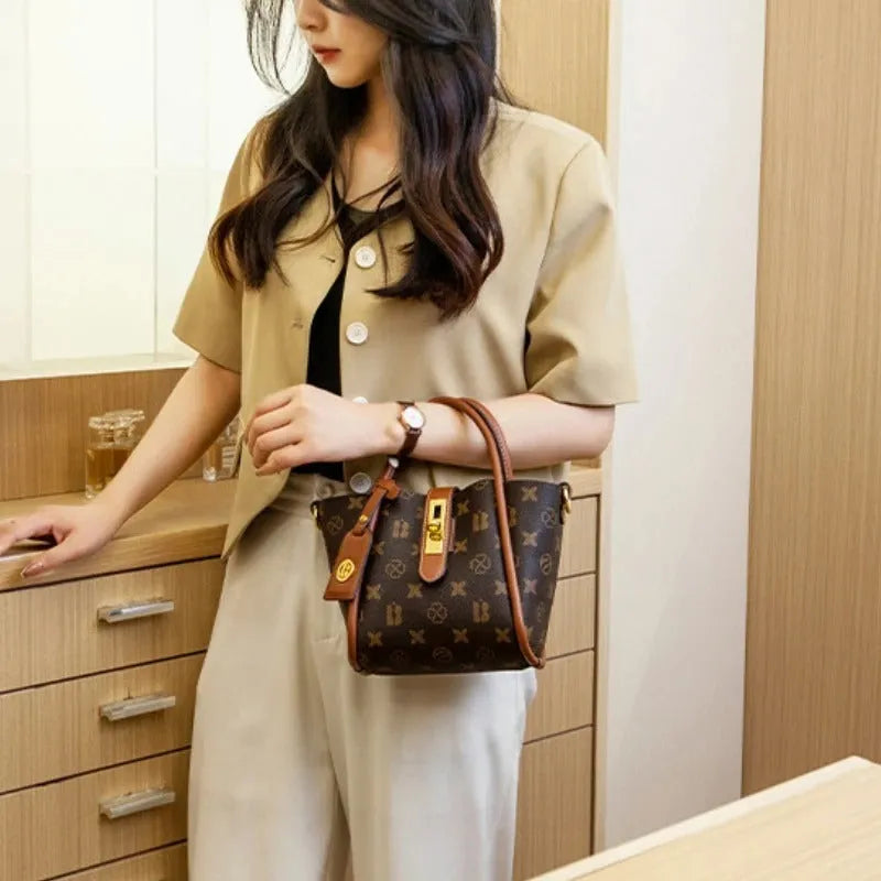 Women's portable PVC bucket messenger bag in coffee brown colour with soft handle and lined interior