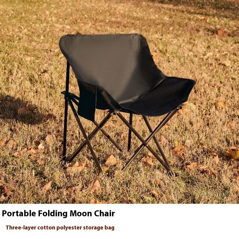Beige portable folding camping chair with steel frame on grass outdoors