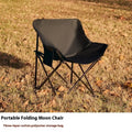 Beige portable folding camping chair with steel frame on grass outdoors