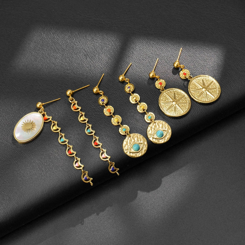 Three pairs of geometric stainless steel earrings showing Eight Awn Star, Eye, and Shell Sun designs