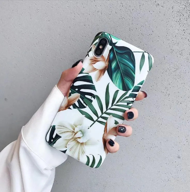 Soft TPU iPhone case with detailed floral and banana leaf art in green tones on the back.