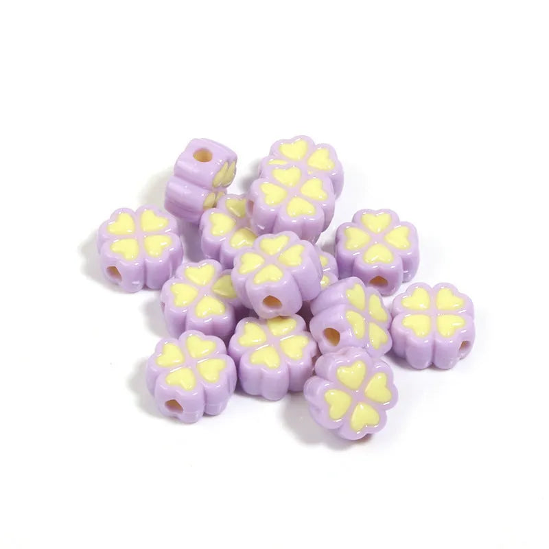 Frosted acrylic four-leaf clover shaped beads in mixed colours on white background