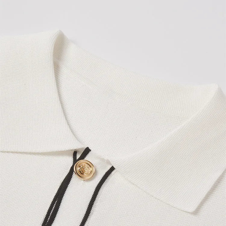 White women's short sleeve cardigan with dark contrast lapels laid flat.