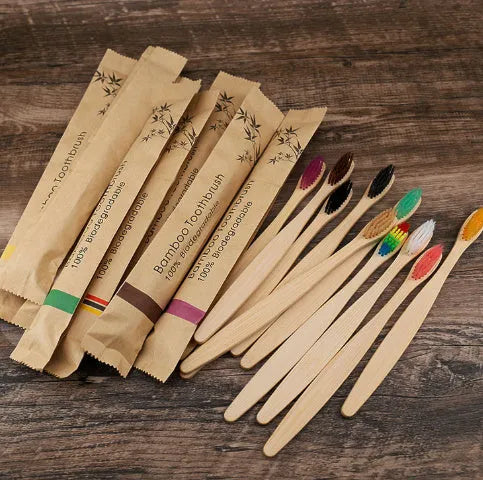 10 bamboo toothbrushes with coloured handles and charcoal bristles displayed together