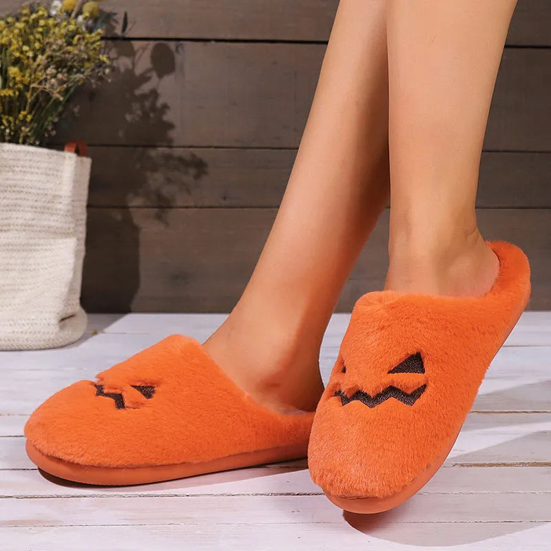 Orange Halloween pumpkin slippers with coral velvet upper and plush lining on a non-slip PVC sole.