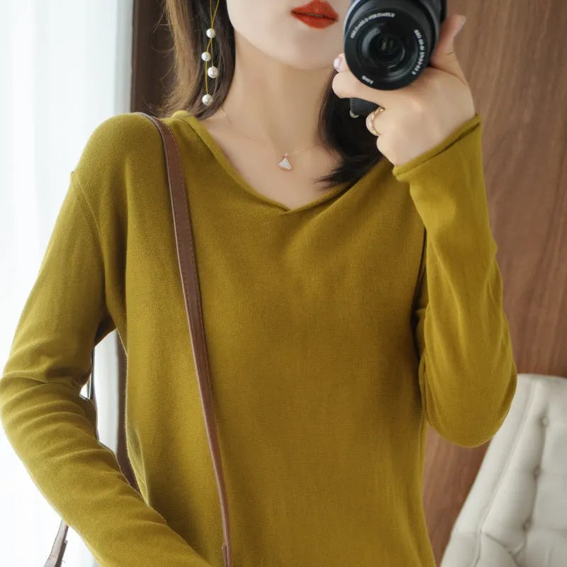 Women's long sleeve V-neck knitwear top in turmeric colour, laid flat to show pullover style and non-ironing fabric.