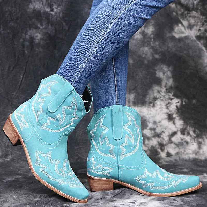 Women's brown cowboy boots with embroidery on the shaft, pointed toe, and a low wedge heel.