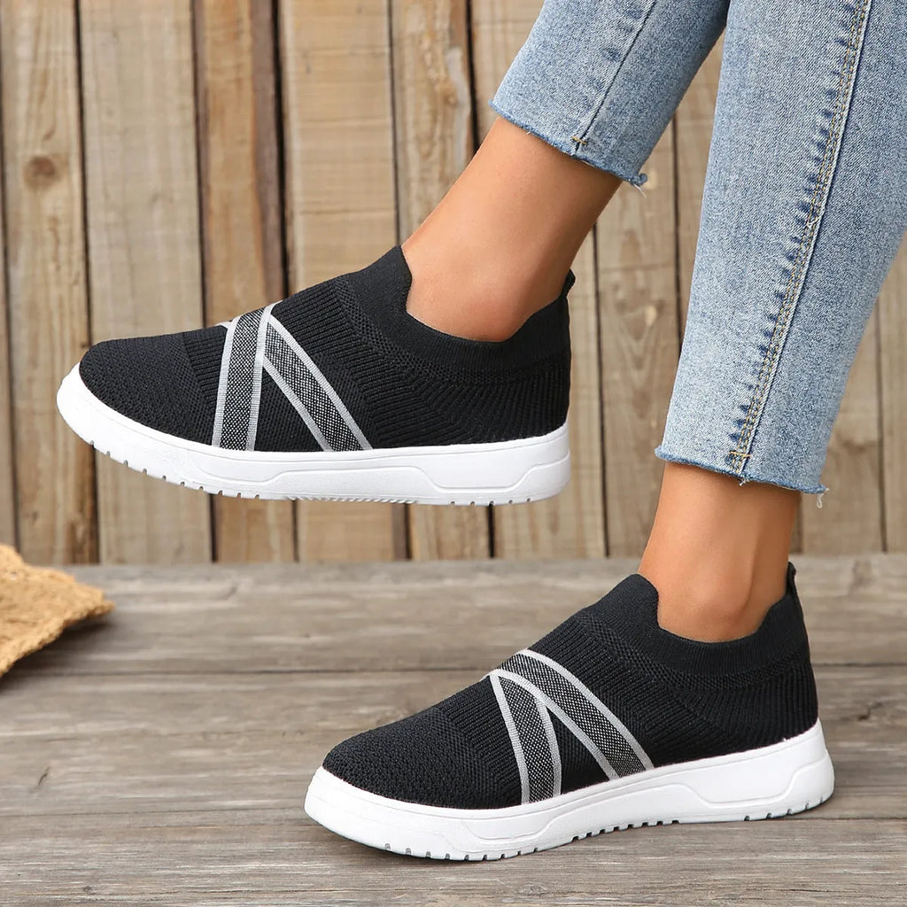 Black women's flat shoes with flyknit mesh upper, round toe, and tassel detail
