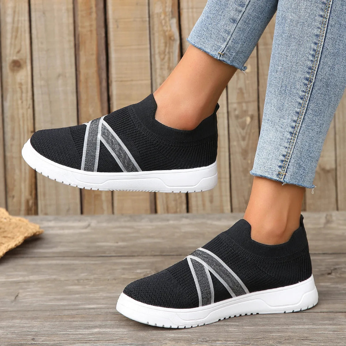 Black women's flat shoes with flyknit mesh upper, round toe, and tassel detail