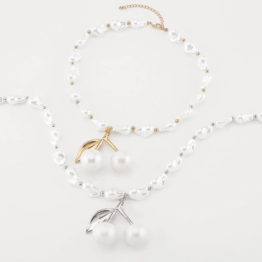 Gold and white K electroplated alloy necklace with irregular cherry fruit pendant and imitation pearls, adjustable chain.
