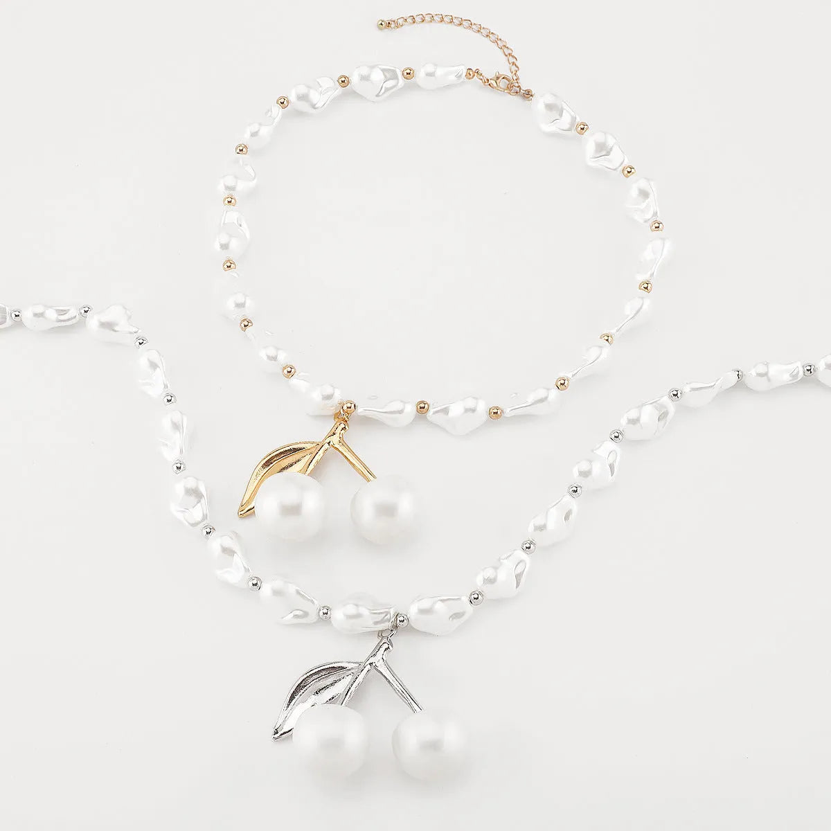 Gold and white K electroplated alloy necklace with irregular cherry fruit pendant and imitation pearls, adjustable chain.