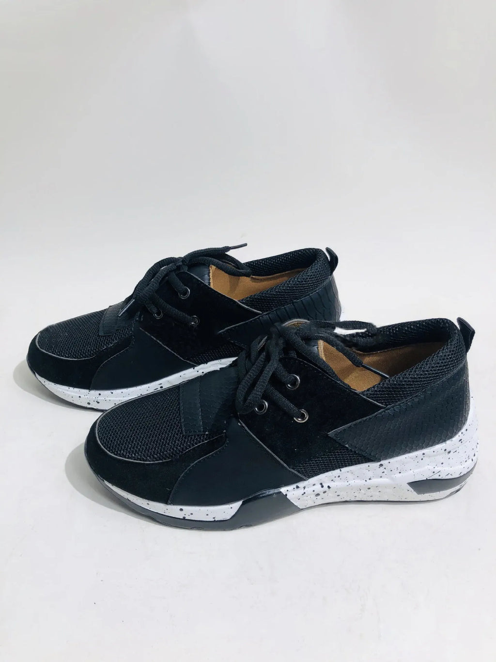 Women's black casual flat sneakers with suede upper and a wedge heel on a breathable fabric base.
