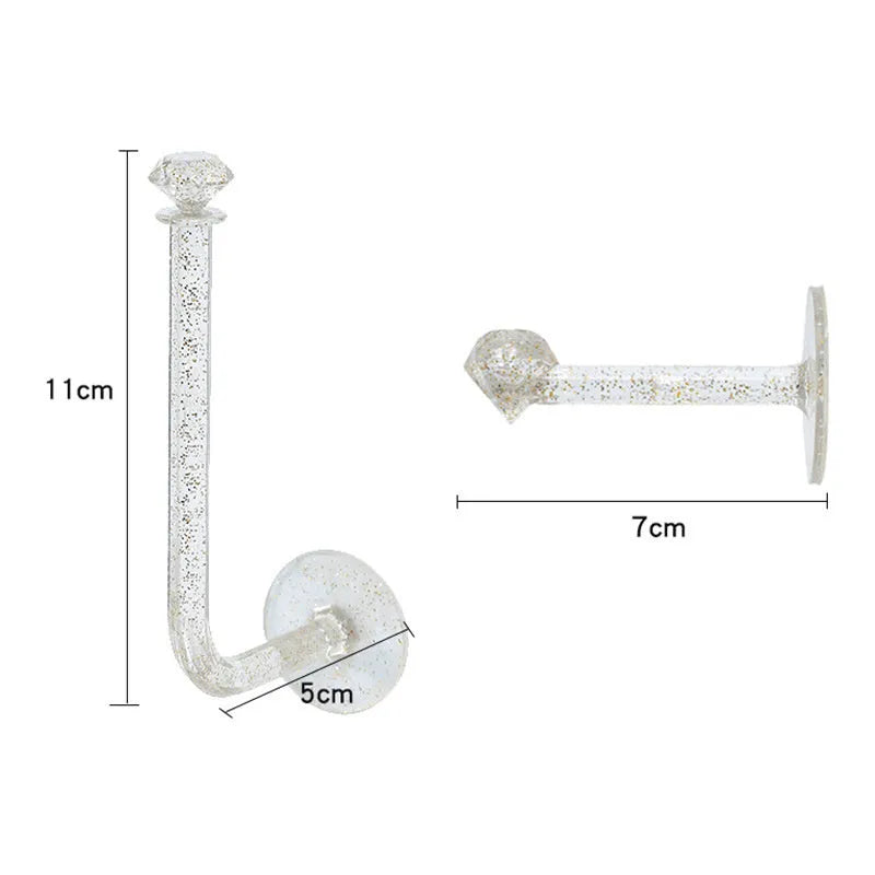 White plastic diamond crystal storage hook mounted on wall holding keys and small accessories