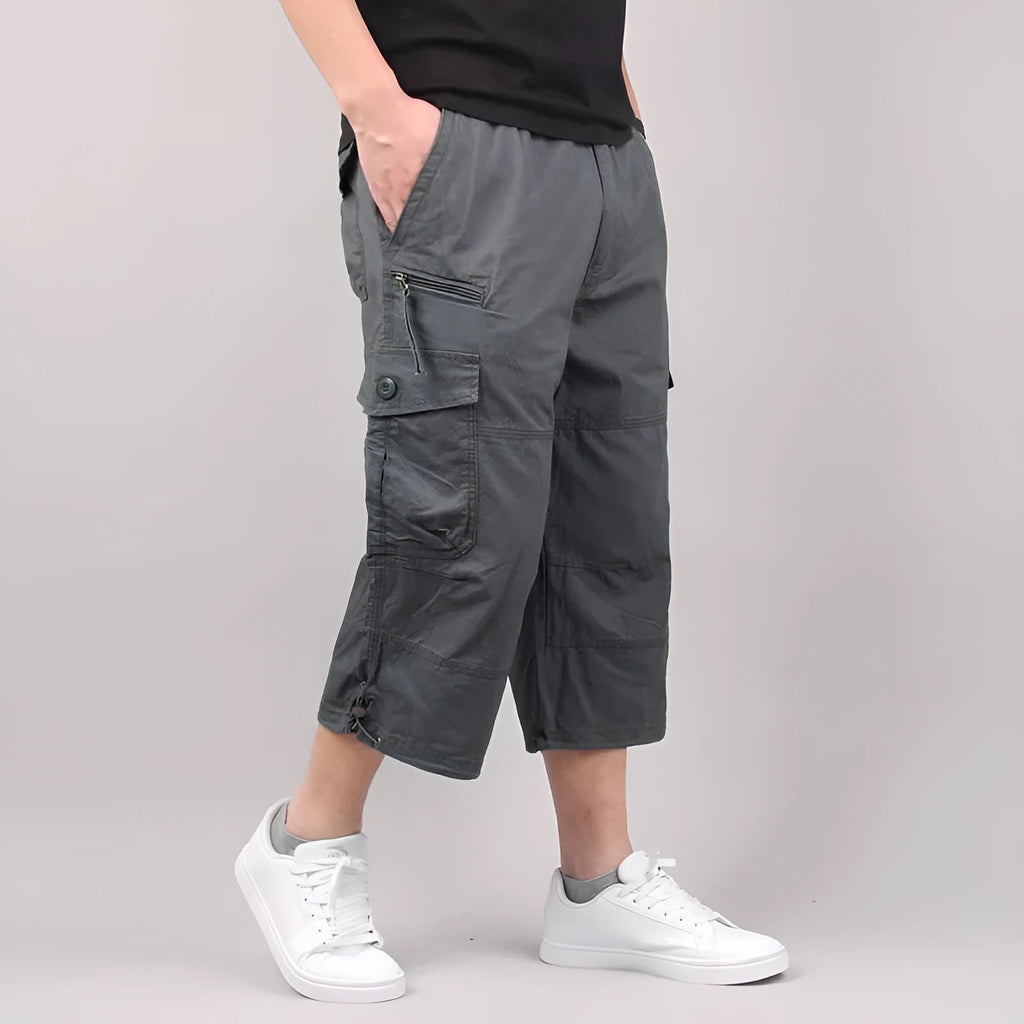 Men's cropped casual trousers in loose fit cotton fabric, shown in khaki colour with sports wear application
