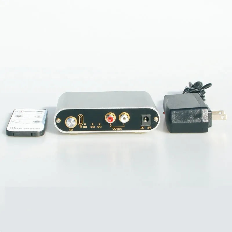 Silver aluminium alloy audio source selector switch unit with front-panel buttons and infrared remote.