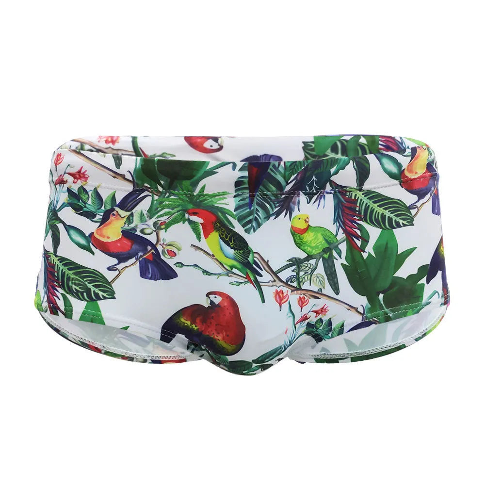Men's blue swimming trunks with a colourful flowers and birds print, showing the boxer style and cup cover.