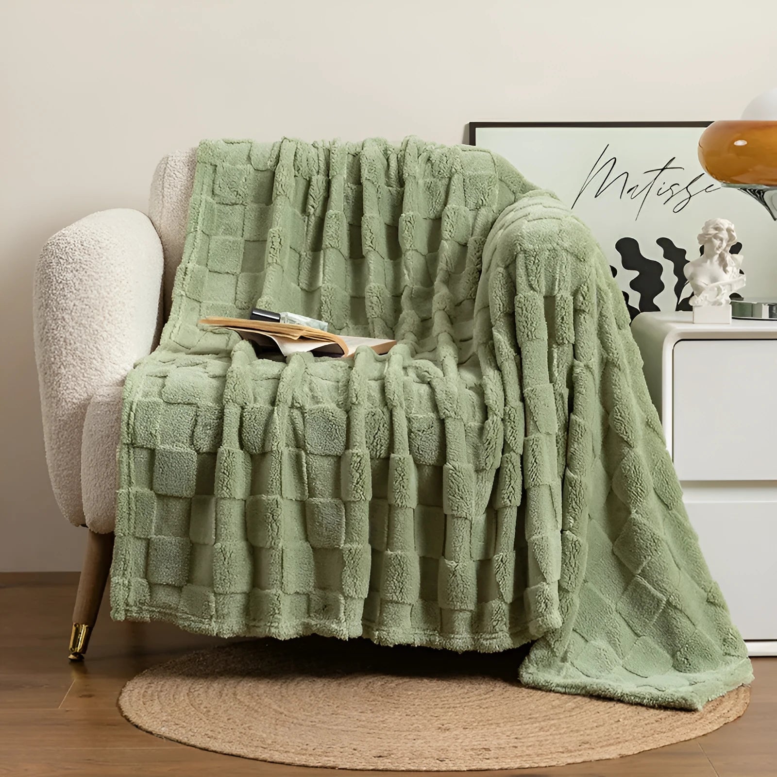 Geometric pattern polyester velvet blanket in dark grey, shown draped over a sofa.