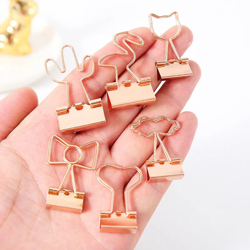 Golden metal stationery clip with a decorative flamingo design on a long tail.