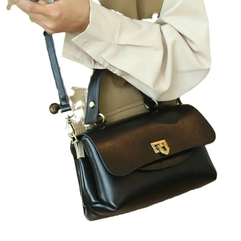Women's brown leather saddleback handbag with double straps and multiple compartments