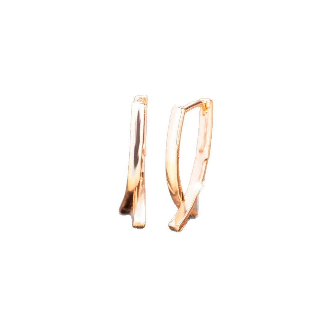 A pair of rose gold coloured cross-shaped stud earrings on a plain background.