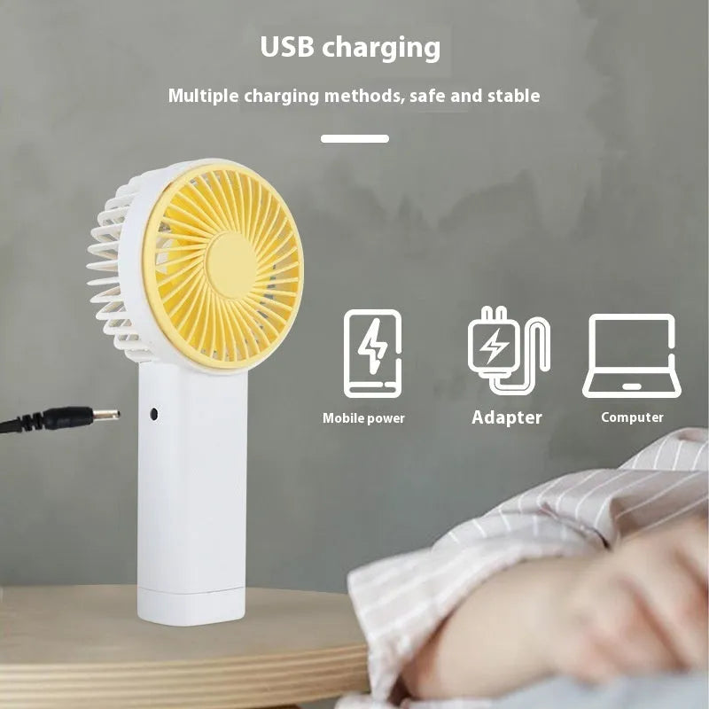 Outdoor portable USB rechargeable handheld fan in pink with three plastic blades and single speed button