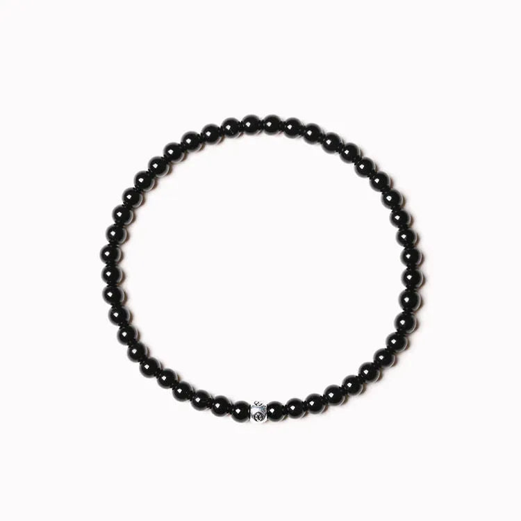 A unisex beaded bracelet with small 4mm obsidian, blue San, and black agate stones in geometric shapes.