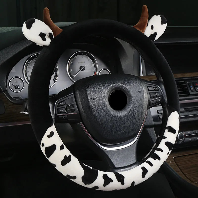 Short plush automotive steering wheel cover in black, showing protective handle detail.