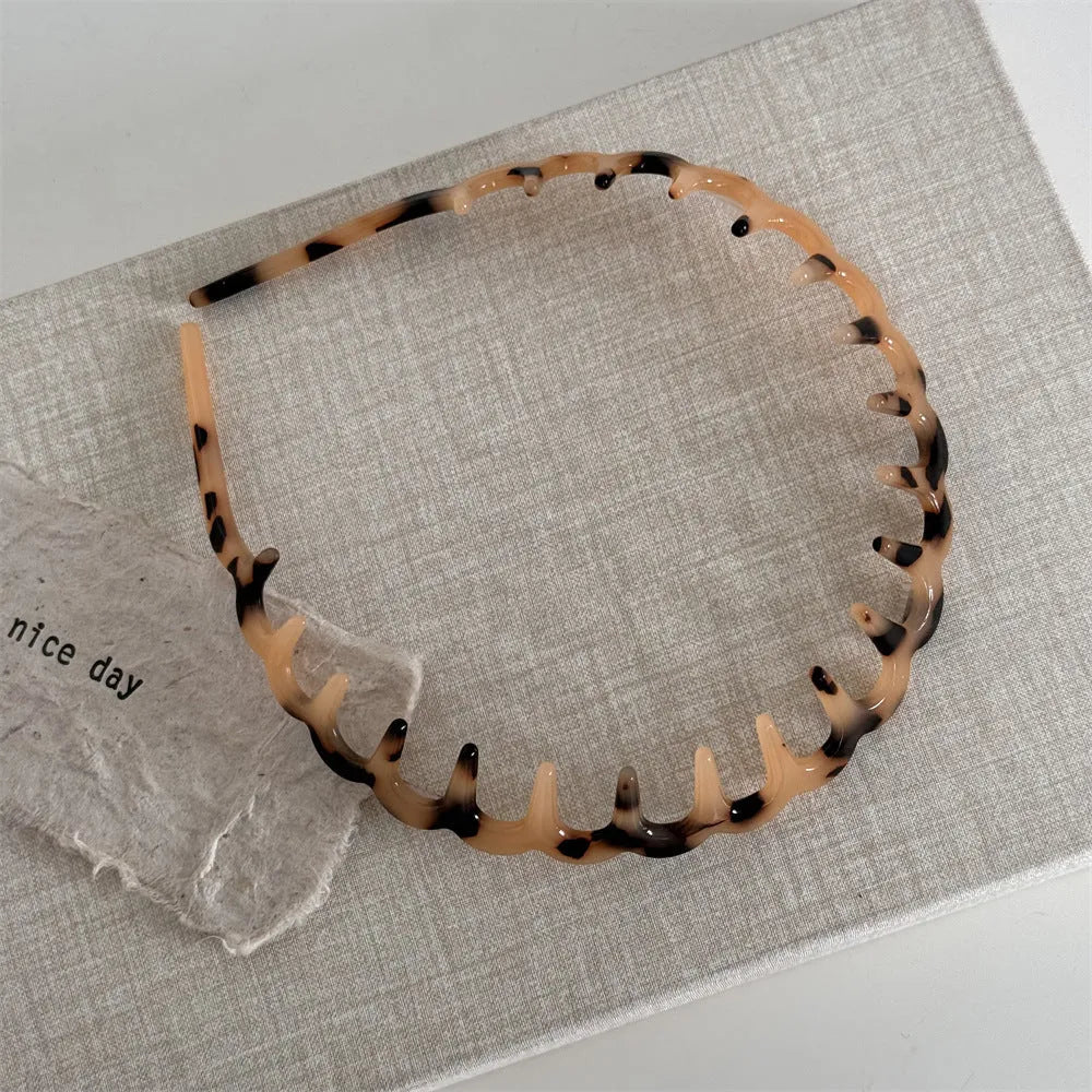 Women's acetate fibre toothed hair hoop in black colour, showing non-slip wave pressure nozzle and irregular Korean-style shape.