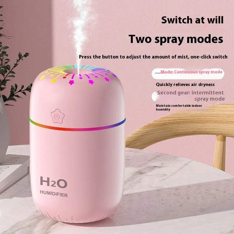 Fireworks A5 white mini USB humidifier with water tank on a wooden desk next to a laptop