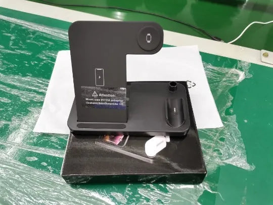 A folding 4-in-1 wireless charger in Space Gray, shown charging an iPhone in vertical stand mode and an Apple Pencil.