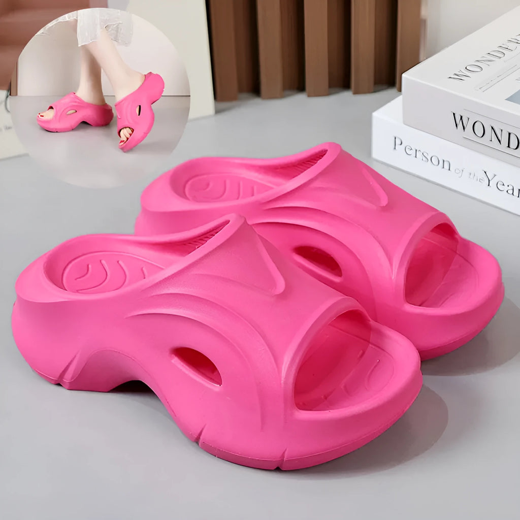 Women's white thick-soled EVA beach slippers with round toe on sand.