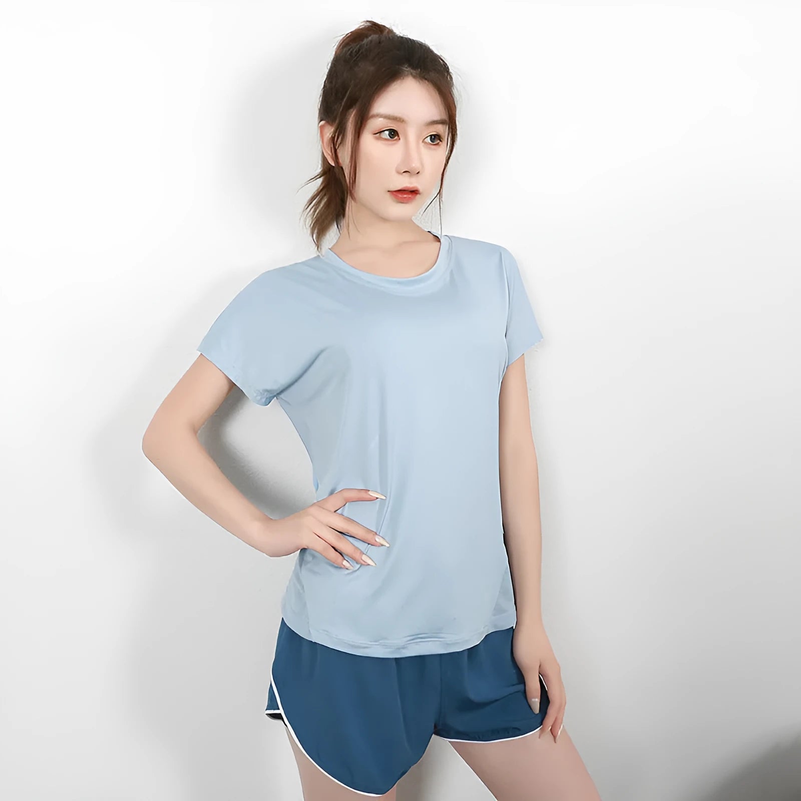 Women's short sleeve polyester sports t-shirt in pink, shown on a hanger.