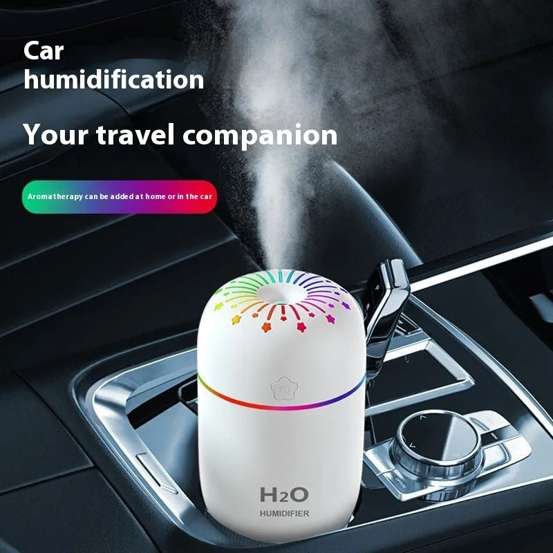 Fireworks A5 white mini USB humidifier with water tank on a wooden desk next to a laptop