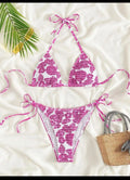 Women's pink floral halter neck swimsuit with briefs on a mannequin.