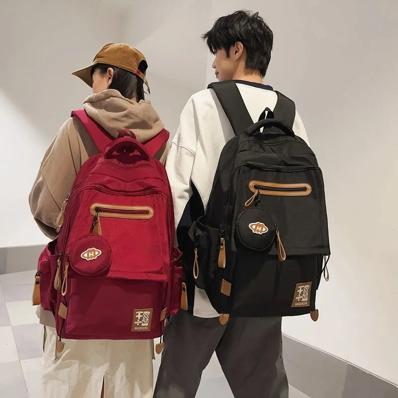 Large black nylon backpack for middle school students with curved shoulder straps and sewing line details