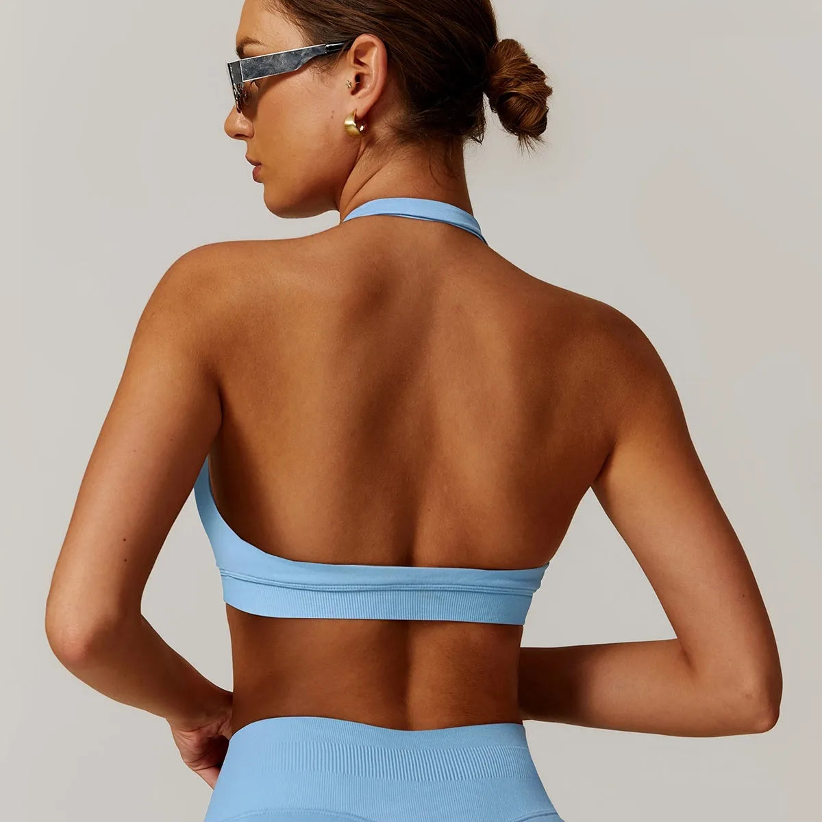 Women's black halter style yoga bra with medium support and hollow design.