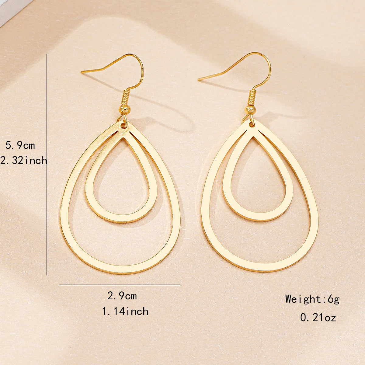 Golden yellow hollow drop earrings made from iron, shown as a pair with an open drop shape