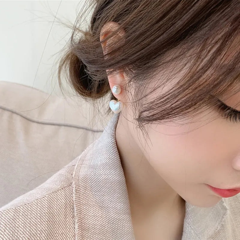 Women's heart-shaped stud earrings with a pearl-like centre in electroplated alloy, Korean style.