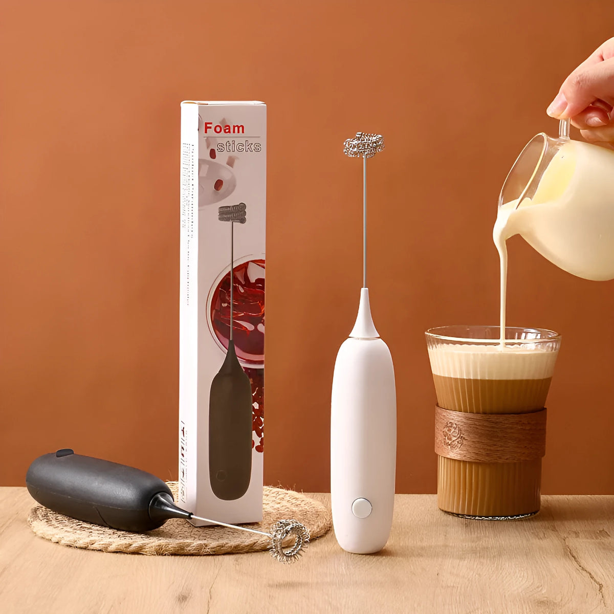 Electric hand-held milk frother in black and white colours for coffee preparation