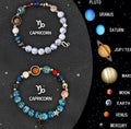 Set of twelve natural stone beaded bracelets, each with a different metal zodiac charm on elastic cord.