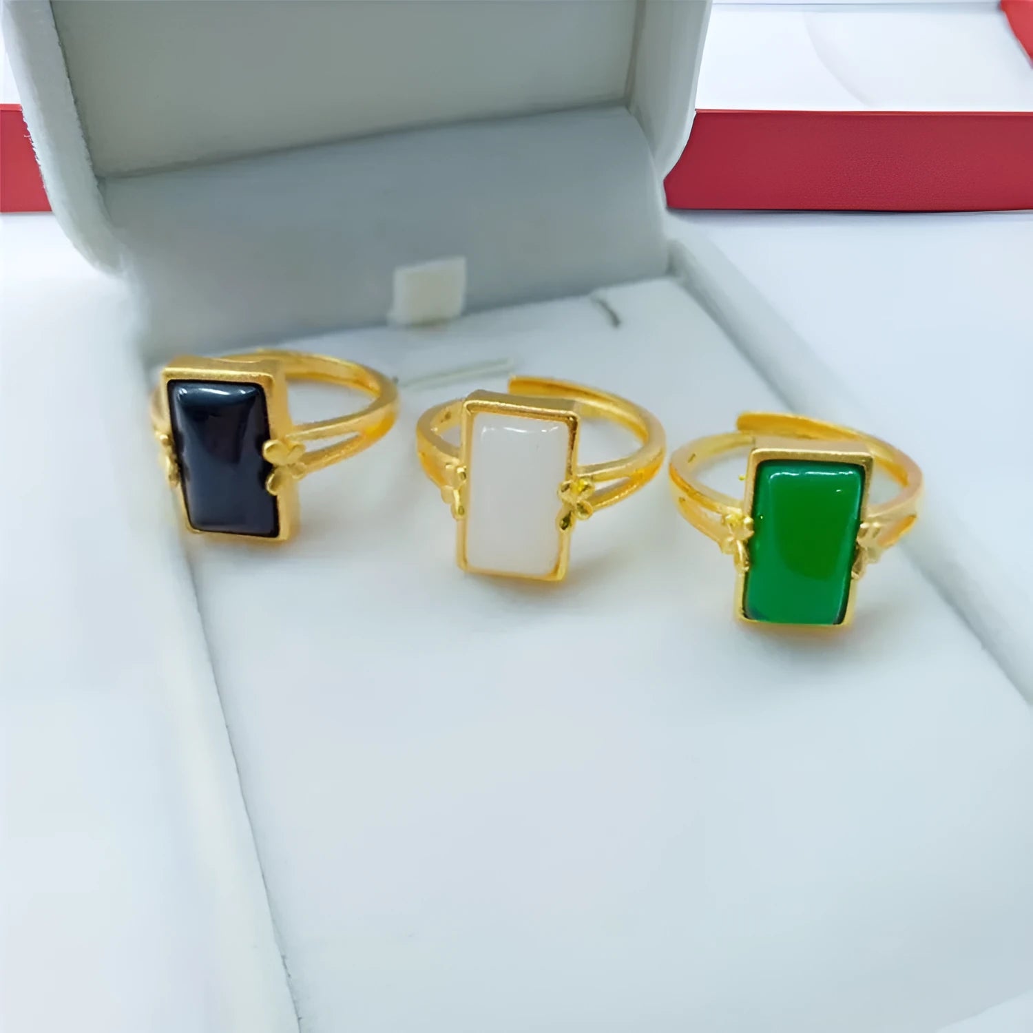 Adjustable gold-plated brass ring with a black electroplated gemstone on a neutral background.