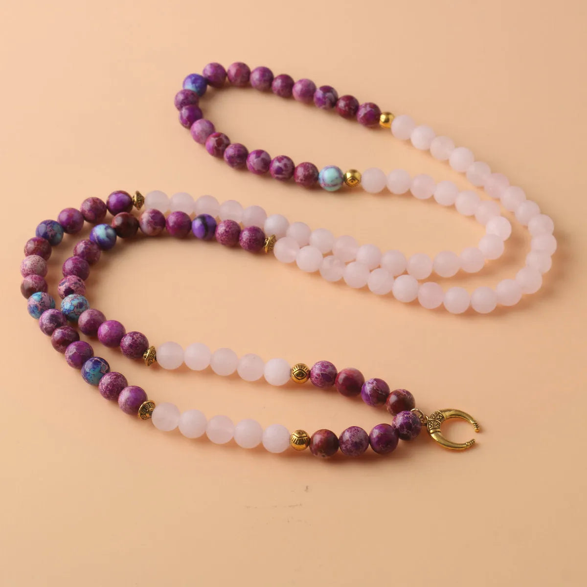 Close-up of a pink emperor stone crystal bead pendant on a necklace chain for casual wear.