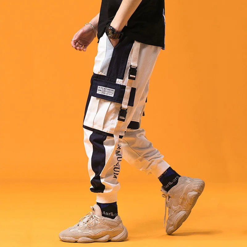 Men's loose fit hip hop beam pants in khaki cotton-rich fabric, mid waist, tether closure, small feet hem, available in black and white.